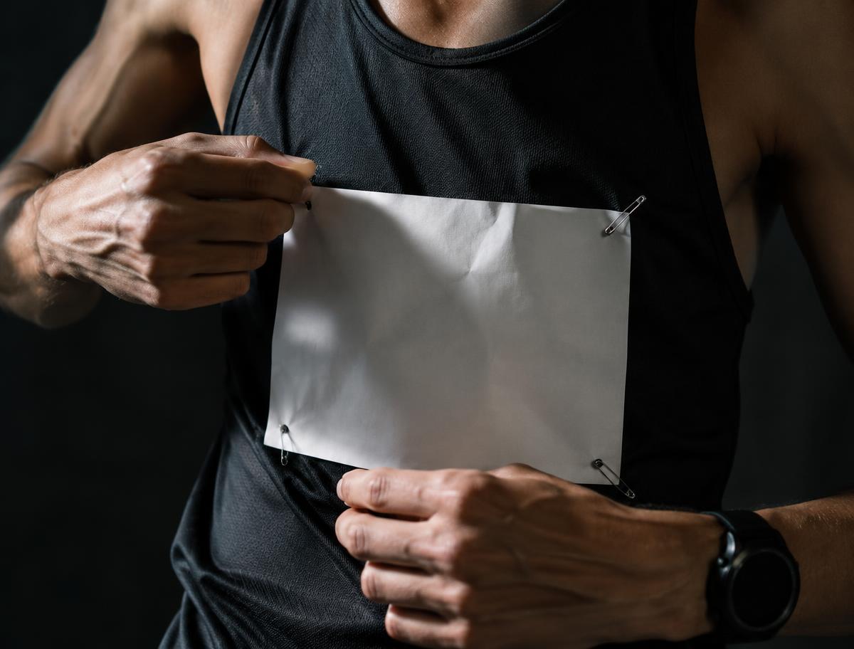 Runner pinning a race bib to a technical vest
