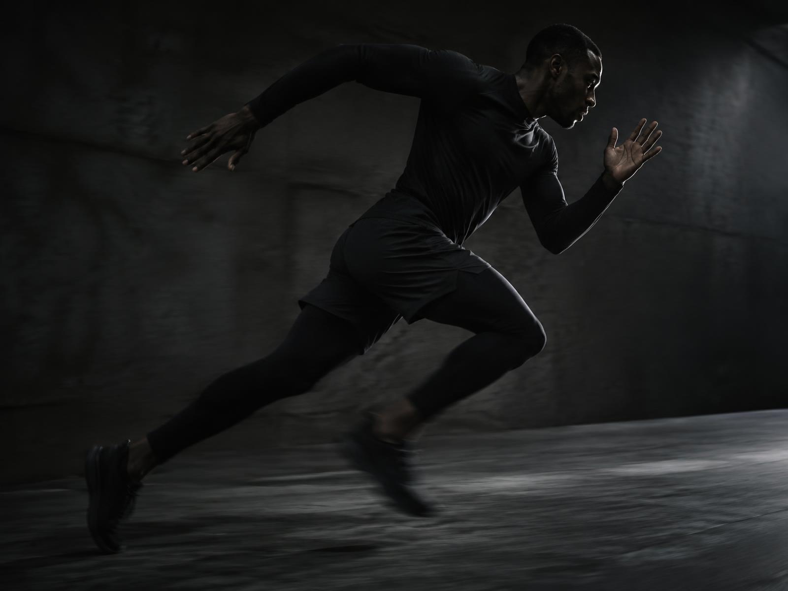 Athlete sprinting through a dark tunnel in ELV3N performance kit